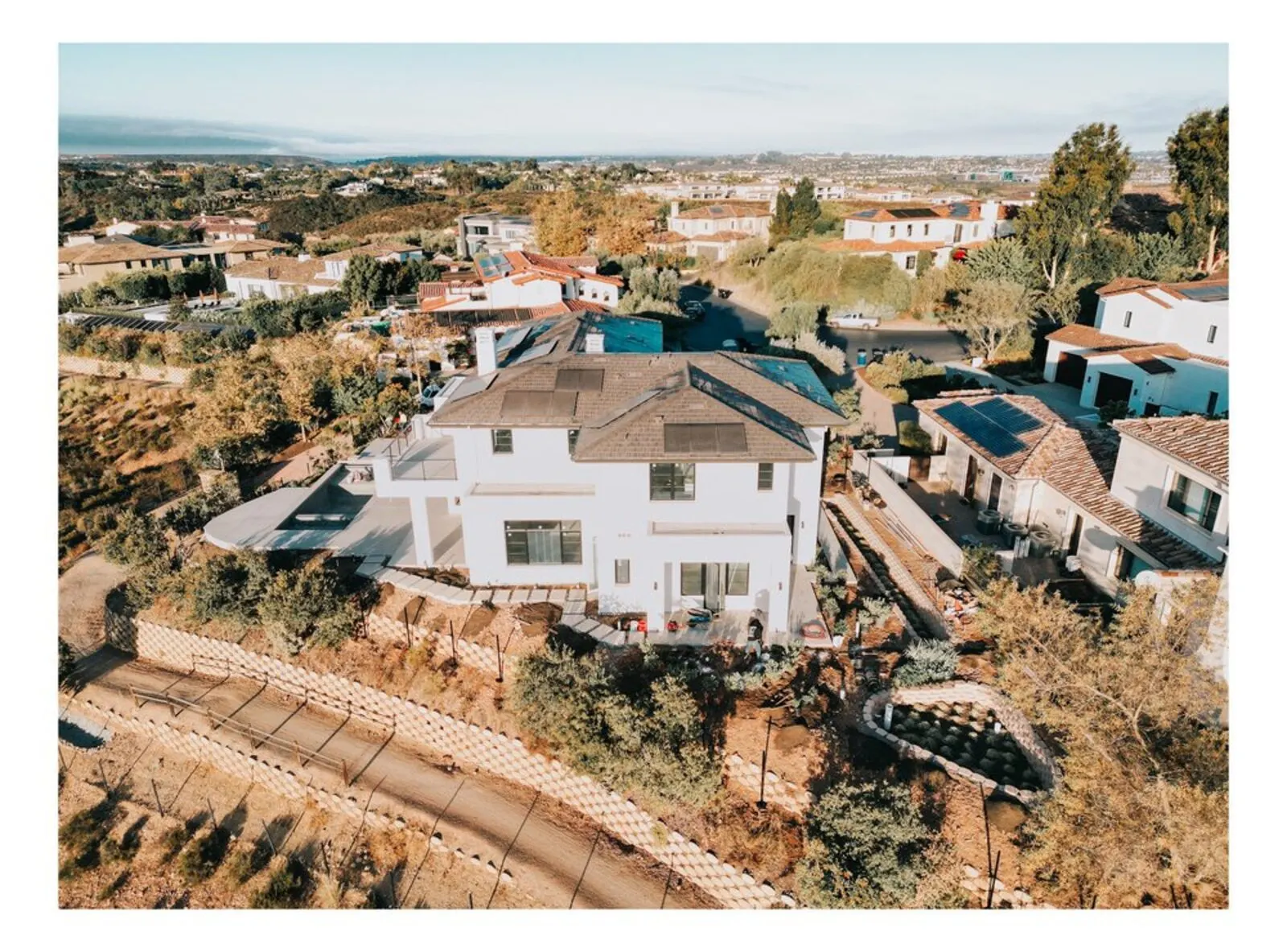 Completed home framing viewed from above with surrounding hillside