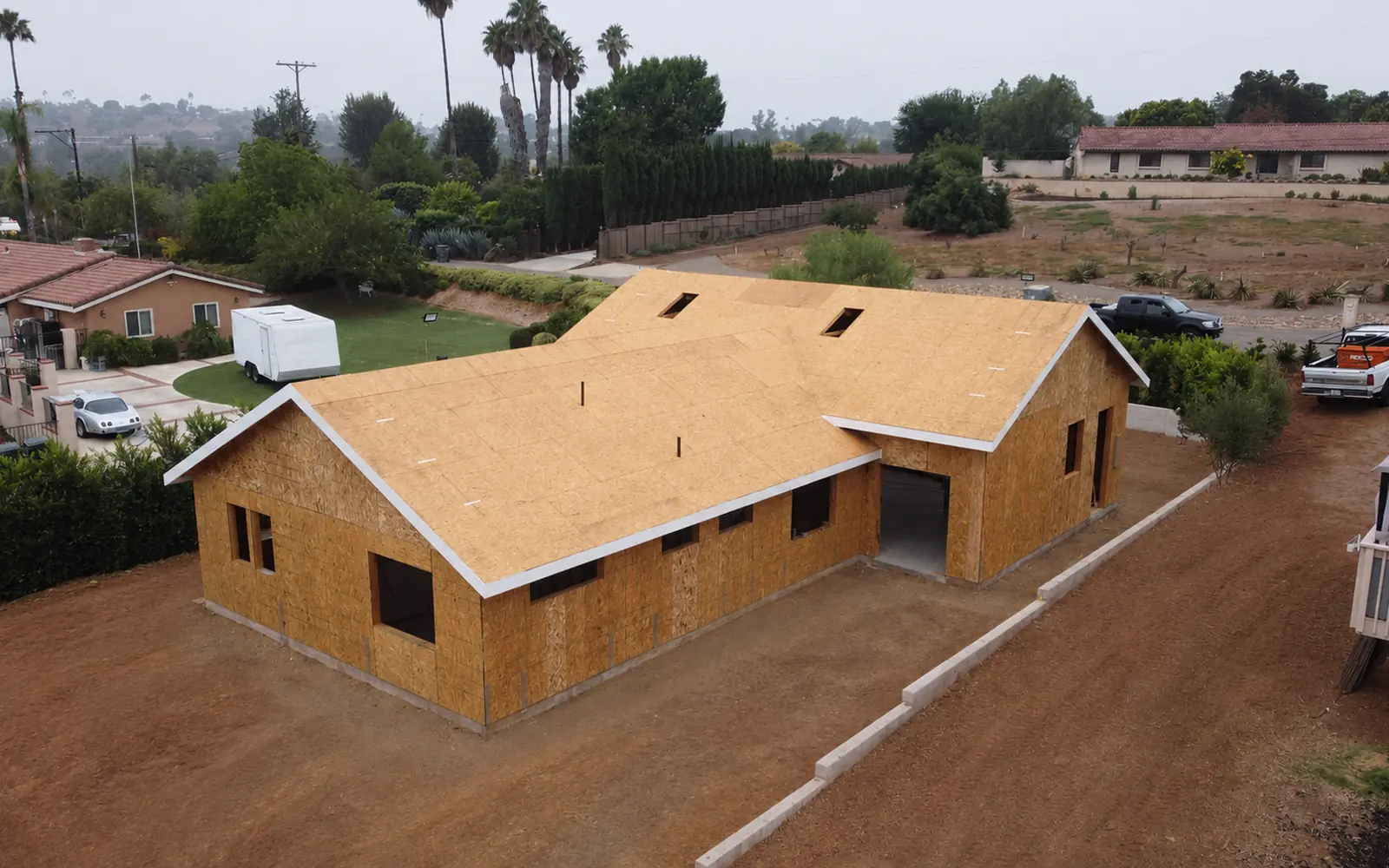 Aerial view of a framed ADU with roof sheathing completed on a San Diego property